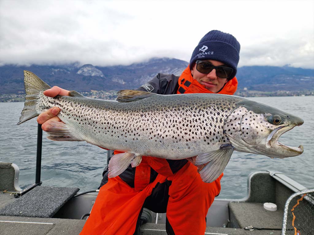 Pêcheur présentant une truite lacustre.